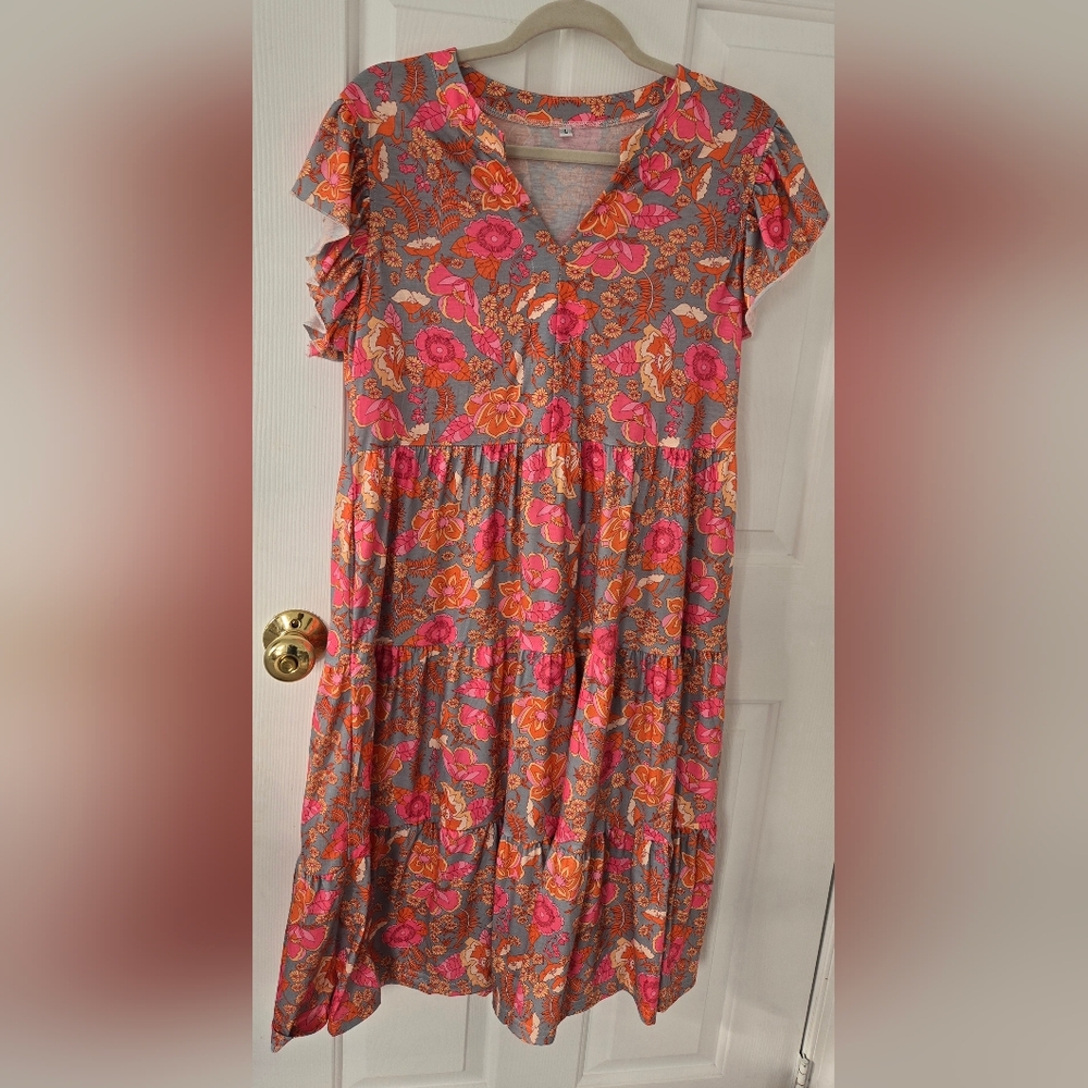 Dress features a v-neck, flutter sleeves, and a flowy midi length with pockets
